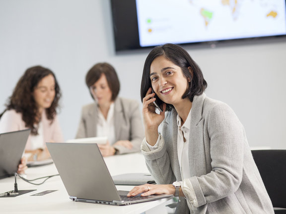 Femme au téléphone qui travaille sur un ordinateur portable