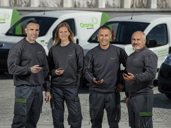 Equipo de hombres y mujeres con coches de fondo