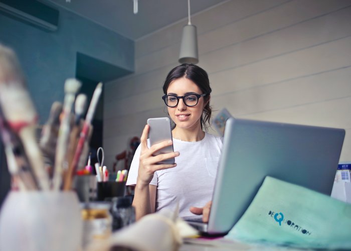 Mujer joven gestionando algo en el teléfono móvil